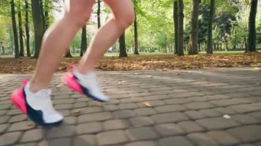 Parkta koşarken spor ayakkabılı kadın bacaklarını kapat.