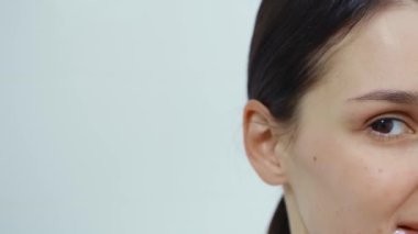 Genç ve güzel bir kadın banyoda yüzüne krem sürüyor..