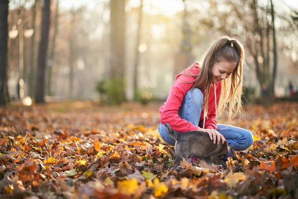 Kleines Mädchen geht mit Hund im Herbstpark spazieren. — Stockfoto