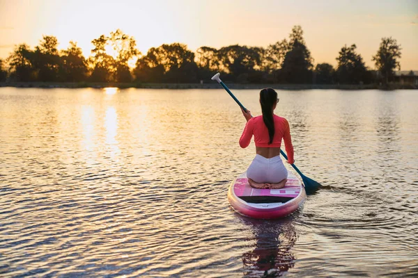 Sporty za pomocą sup board na wieczorny trening na jeziorze — Zdjęcie stockowe