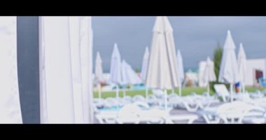 Tatil köyünde güneşli havuz ve şemsiyeler.