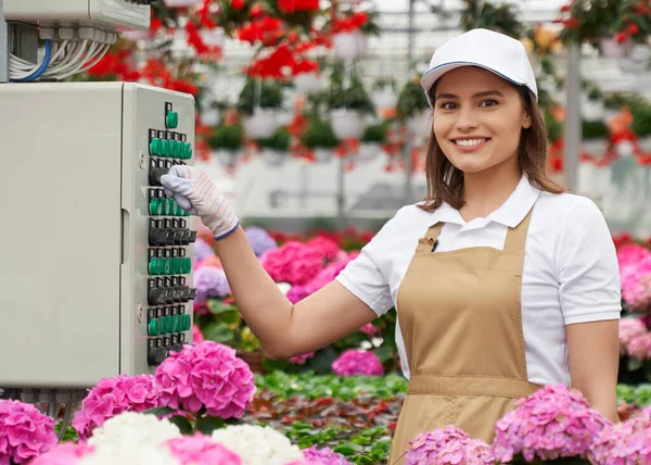 Woman using machine that controlling watering flowers — Stock Photo, Image