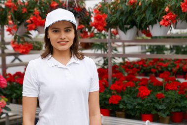 Kızıl çiçeklerle çalışan güzel bir genç bayan..