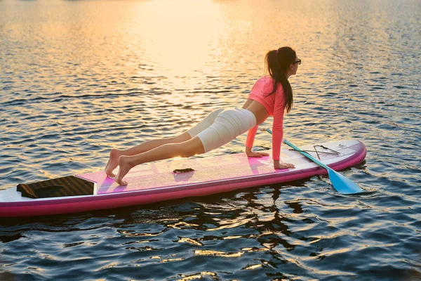 Mujer activa de pie en posición de tablón en sup board — Foto de Stock