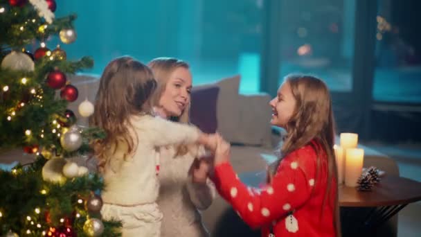 Мама веселится с милыми дочерьми возле рождественской елки — стоковое видео