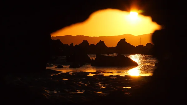 Coucher de soleil rocheux vu à travers une roche érodée — Photo