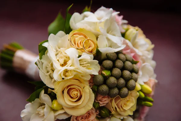 Ringe am schönen Hochzeitsstrauß im rustikalen Stil mit Rose — Stockfoto