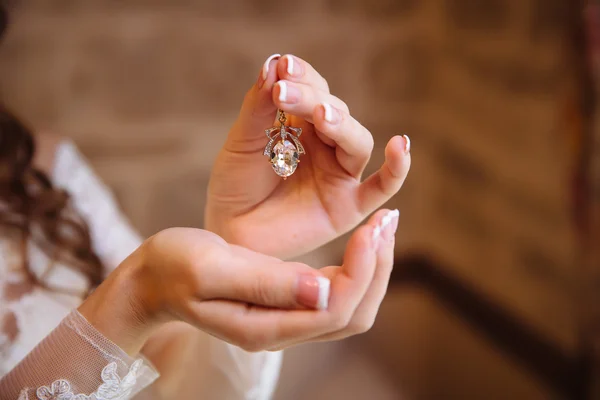 Earring in handen van de bruid — Stockfoto