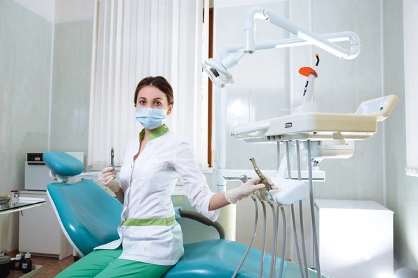 Dentist woman with medical instruments in the dental office doing procedures — Stock Photo, Image