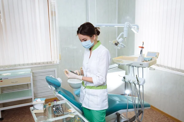 Dentiste femme avec des instruments médicaux dans le cabinet dentaire faisant des procédures — Photo