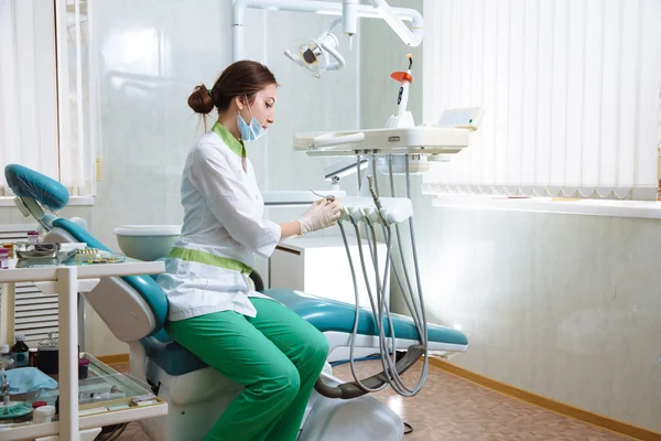 在做程序的牙科诊所的医疗仪器的牙医女人 — 图库照片