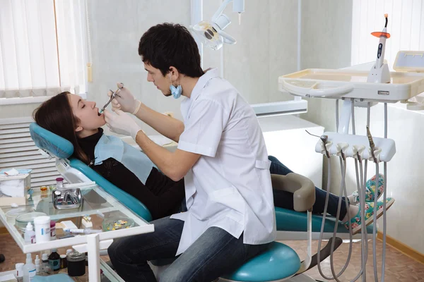 Hombre dentista haciendo procedimientos con su paciente en el consultorio dental — Foto de Stock