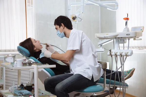 Hombre dentista haciendo procedimientos con su paciente en el consultorio dental — Foto de Stock