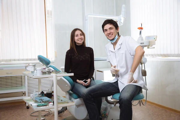 Homem dentista com seu paciente sorrindo no consultório odontológico — Fotografia de Stock