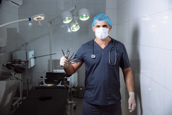 Man van de chirurg in operatiekamer met medische hulpmiddelen in zijn handen — Stockfoto