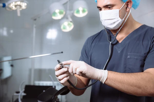 Man van de chirurg in operatiekamer met medische hulpmiddelen in zijn handen — Stockfoto