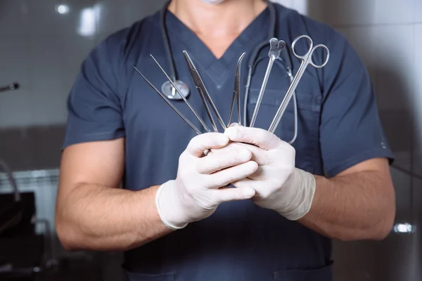 Doctor sosteniendo instrumentos médicos en sus manos. herramientas médicas estériles —  Fotos de Stock