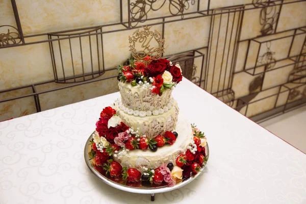 Multilevel sweet wedding cake decorated with strawberries and ot