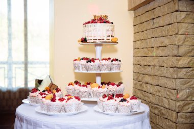 Tatlı çok düzeyli düğün pastası çiçeklerle süslenmiş. Şeker çubuğu