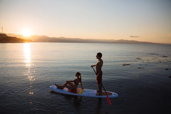Silueta de pareja perfecta participar stand-up paddle boarding — Foto de Stock