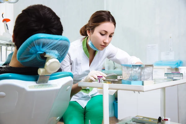 Une dentiste avec un patient masculin au cabinet dentaire. Concept de santé — Photo