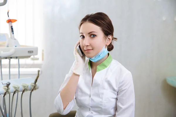 Dentista a falar ao telefone no consultório dentário. Conceito de saudável — Fotografia de Stock