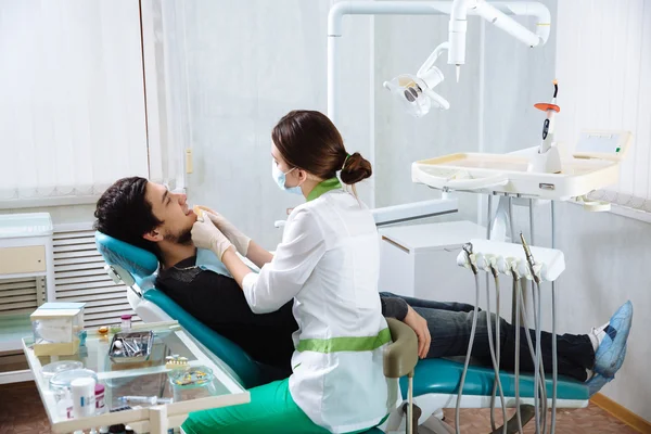 Dentista femenina con paciente masculino en consultorio dental. Concepto de saludable — Foto de Stock