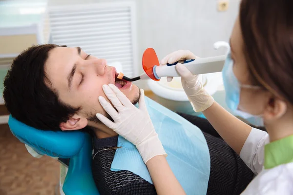 Hombre joven paciente en el consultorio del dentista. Concepto de saludable — Foto de Stock