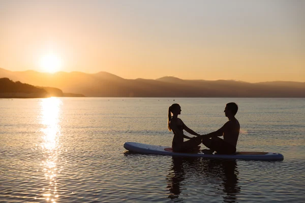 Silhouette di coppia perfetta impegnarsi standup paddle boarding — Foto Stock