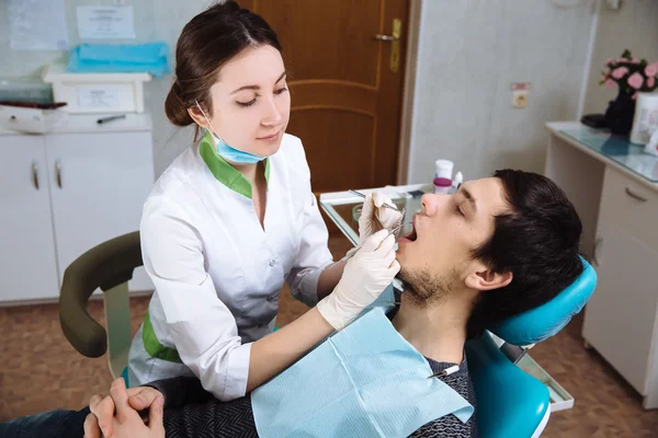 Une dentiste avec un patient masculin au cabinet dentaire. Concept de santé — Photo