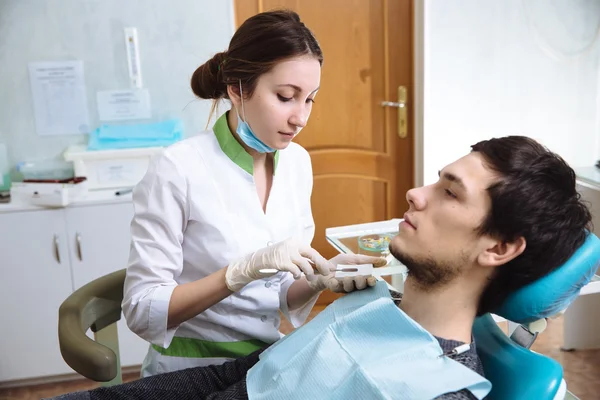 Une dentiste avec un patient masculin au cabinet dentaire. Concept de santé — Photo