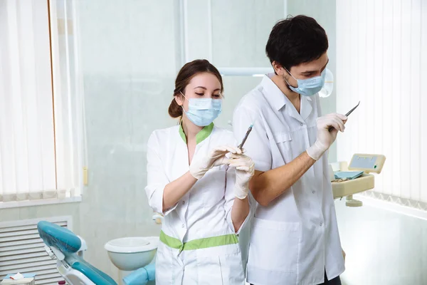 Dos dentistas retratan a hombres y mujeres en el consultorio dental. Concepto de saludable — Foto de Stock