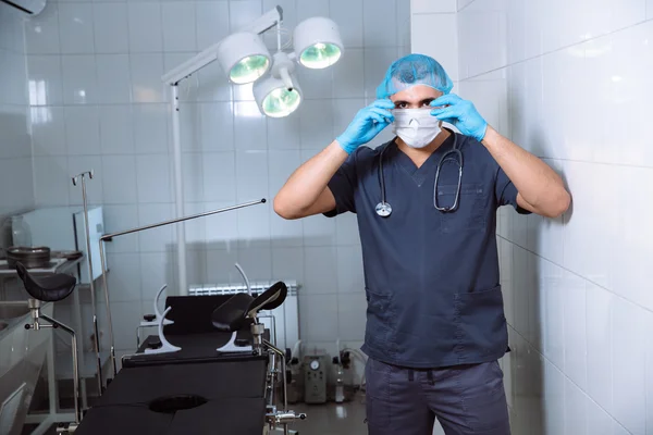 Young man surgeon takes on his protective glasses after operation in hospital. — Stock Photo, Image