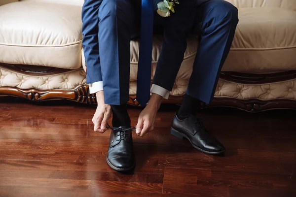 Biznesmen ubierający się w klasyczne, eleganckie buty. Oblubienica w dniu ślubu, wiązanie sznurowadeł i przygotowanie. — Zdjęcie stockowe
