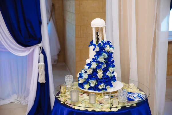Sweet multilevel wedding cake decorated with blue flowers