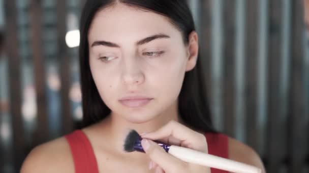 Hand brengt matting agent op gezicht van mooie jonge Kaukasische brunette meisje — Stockvideo