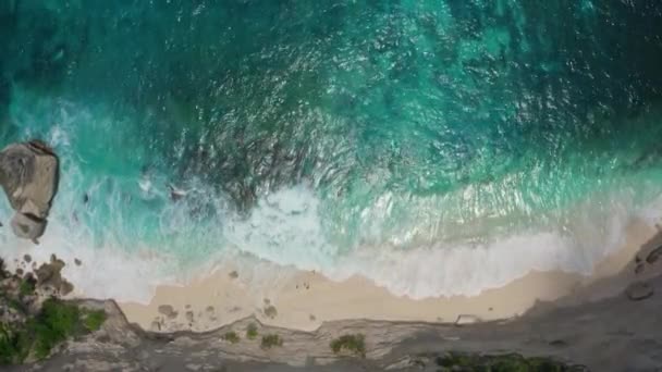 Aerial view of clear turquoise sea waves splashing along the sandy beach — Stock Video