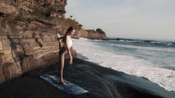 Молодая белая стройная гибкая красивая женщина-инструктор по йоге делает асану — стоковое видео