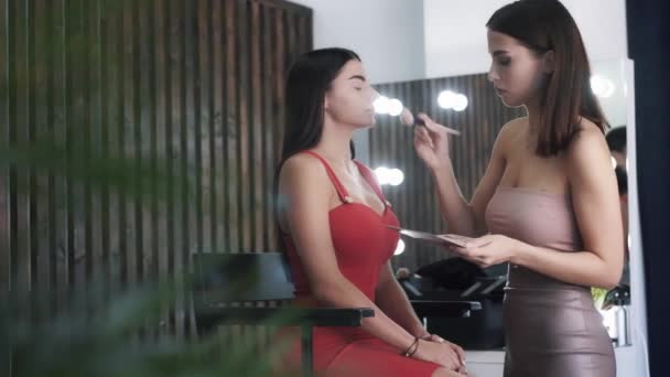 Vrij positief jong Kaukasisch brunette make-up kunstenaar past blozen — Stockvideo