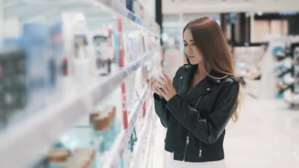 Pensativo joven caucásica hermosa mujer toma lejos un frasco de crema — Vídeo de stock