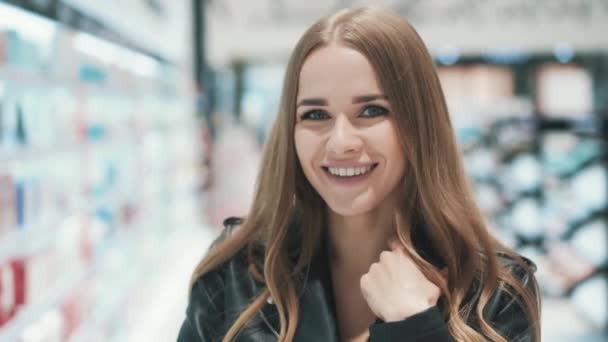 Närbild porträtt av en positiv vacker ung kvinna poserar i snabbköpet — Stockvideo