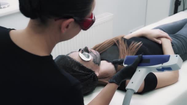 Young woman beautician doing procedure of carbon peeling — Stock Video