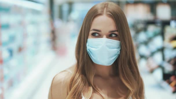 Πορτρέτο της χαριτωμένης νεαρής γαλανομάτα καυκάσιας γυναίκας με ιατρική μάσκα — Αρχείο Βίντεο