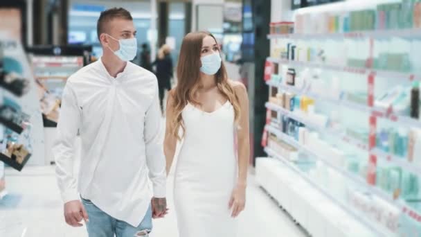 Mladý pár hezká dívka a odvážný chlap v lékařských maskách — Stock video