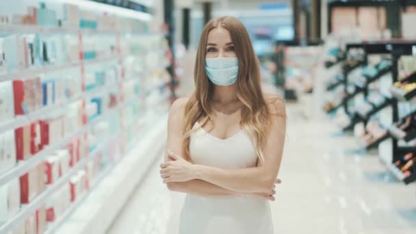 Linda joven caucásica mujer en máscara médica posando en un supermercado — Vídeo de stock
