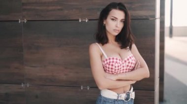 Kırmızı bluzlu, esmer, çekici, esmer bir kadın. 