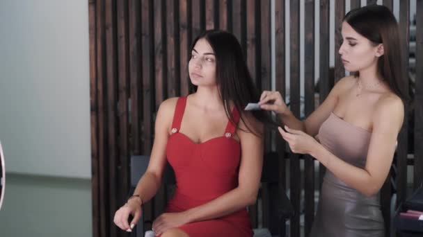 Жінка у верхній частині культури розчісує волосся красивої чарівної білої жінки — стокове відео