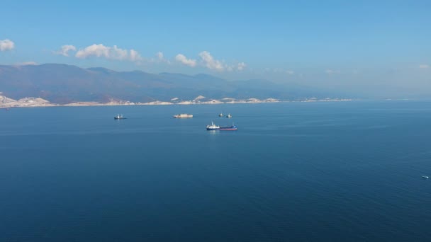 Vista aérea de buques de carga y servicio navegan más allá de las costas rocosas escénicas — Vídeo de stock