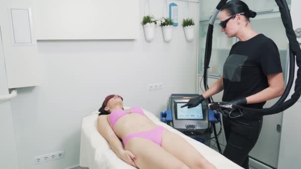 Schoonheidsspecialiste past een microstroom body corrector aan — Stockvideo