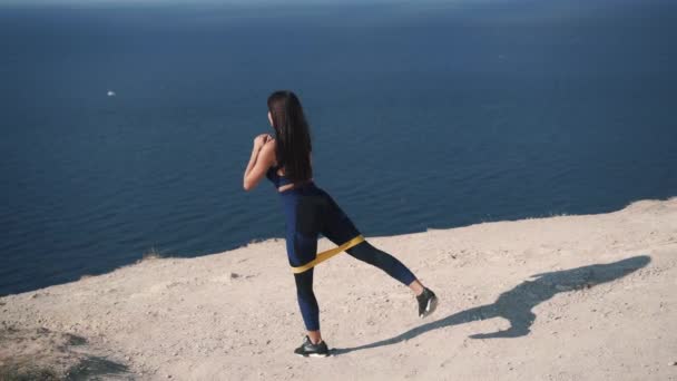 Zwolniony ruch biały młody brunetka w sportowy odzież robi ćwiczenia dla nogi — Wideo stockowe